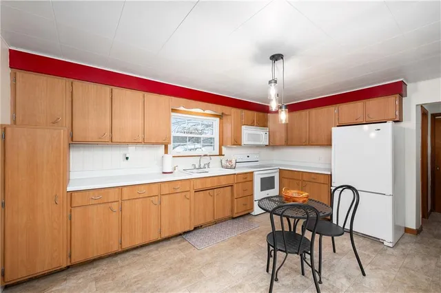 a kitchen with stainless steel appliances granite countertop a stove top oven a sink dishwasher and white cabinets with wooden floor