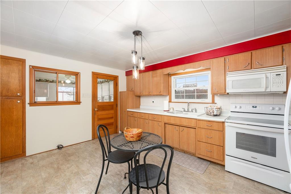 1080 Breakneck Bridge Road Portersville, PA 16051 - Photo 18 of 45 a kitchen with stainless steel appliances granite countertop a stove top oven a sink dishwasher a dining table and chairs with wooden floor