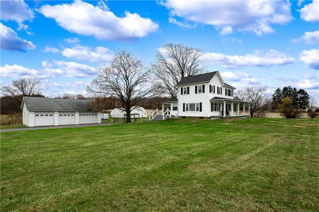 a view of a big house with a big yard and large trees