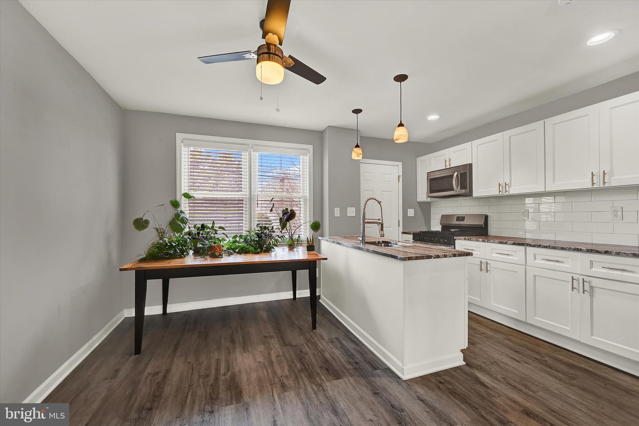 3482 Dunhaven Road Dundalk, MD 21222 - Photo 7 of 33 a kitchen with wooden floors and white cabinets
