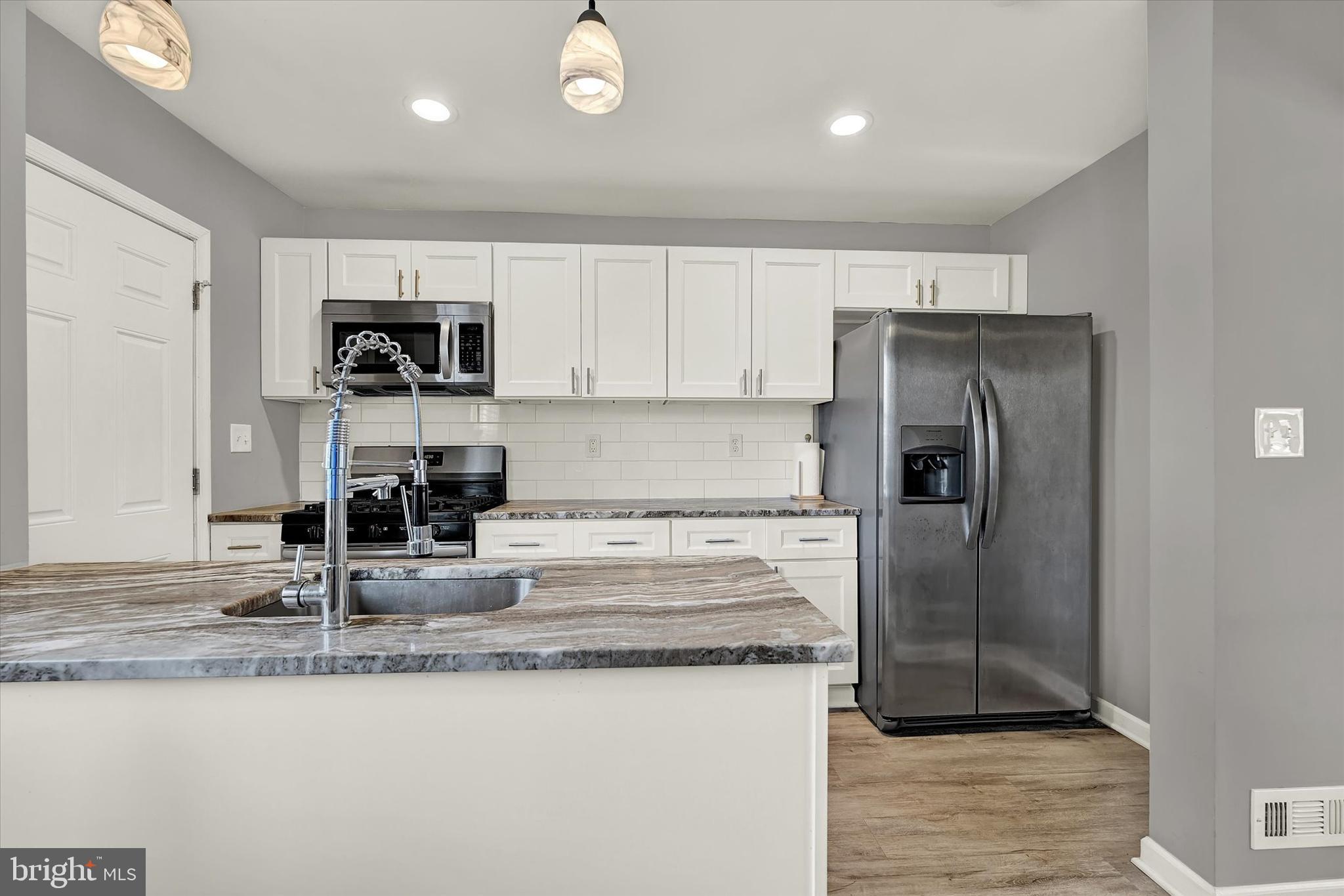 3482 Dunhaven Road Dundalk, MD 21222 - Photo 9 of 33 a kitchen with stainless steel appliances granite countertop a refrigerator a stove and a sink