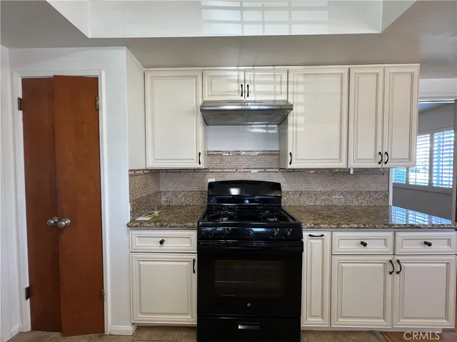 a kitchen with granite countertop a stove and a cabinets