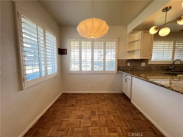 a kitchen with granite countertop a stove a sink and a large window