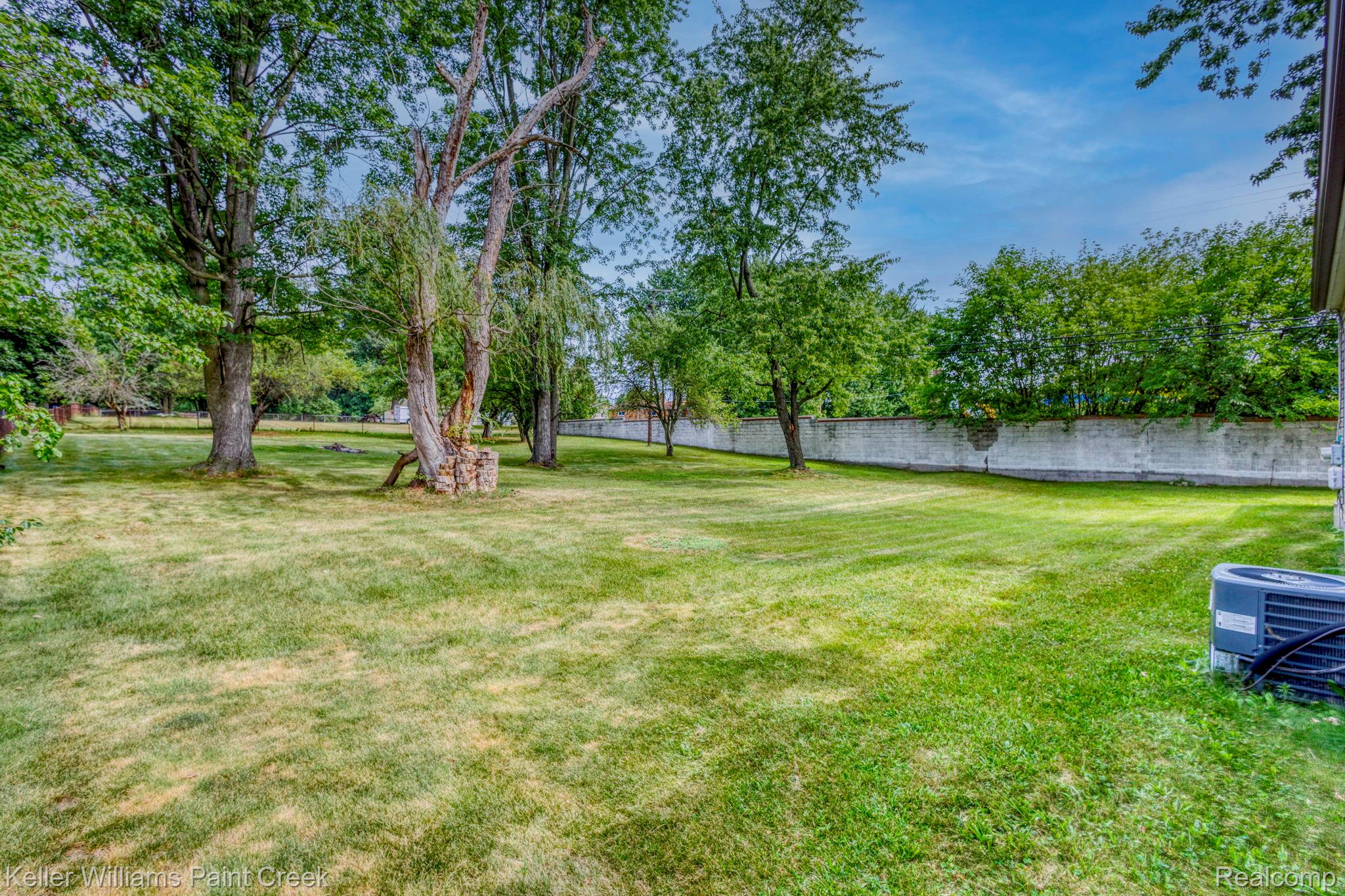 2244 Hammerslea Road Lake Orion, MI 48359 - Photo 17 of 21 Expansive lawn area featuring mature trees and a solid perimeter wall