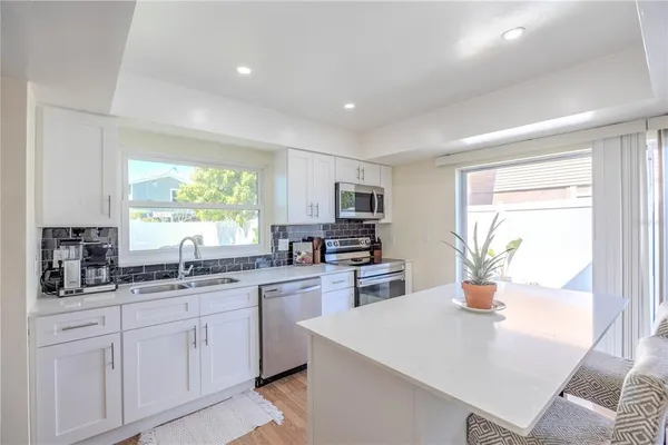 a kitchen with white cabinets and sink
