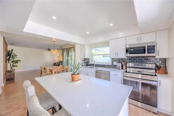 a kitchen with a table chairs microwave and cabinets