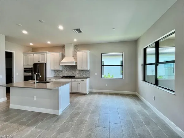 a large kitchen with kitchen island a sink stainless steel appliances and cabinets