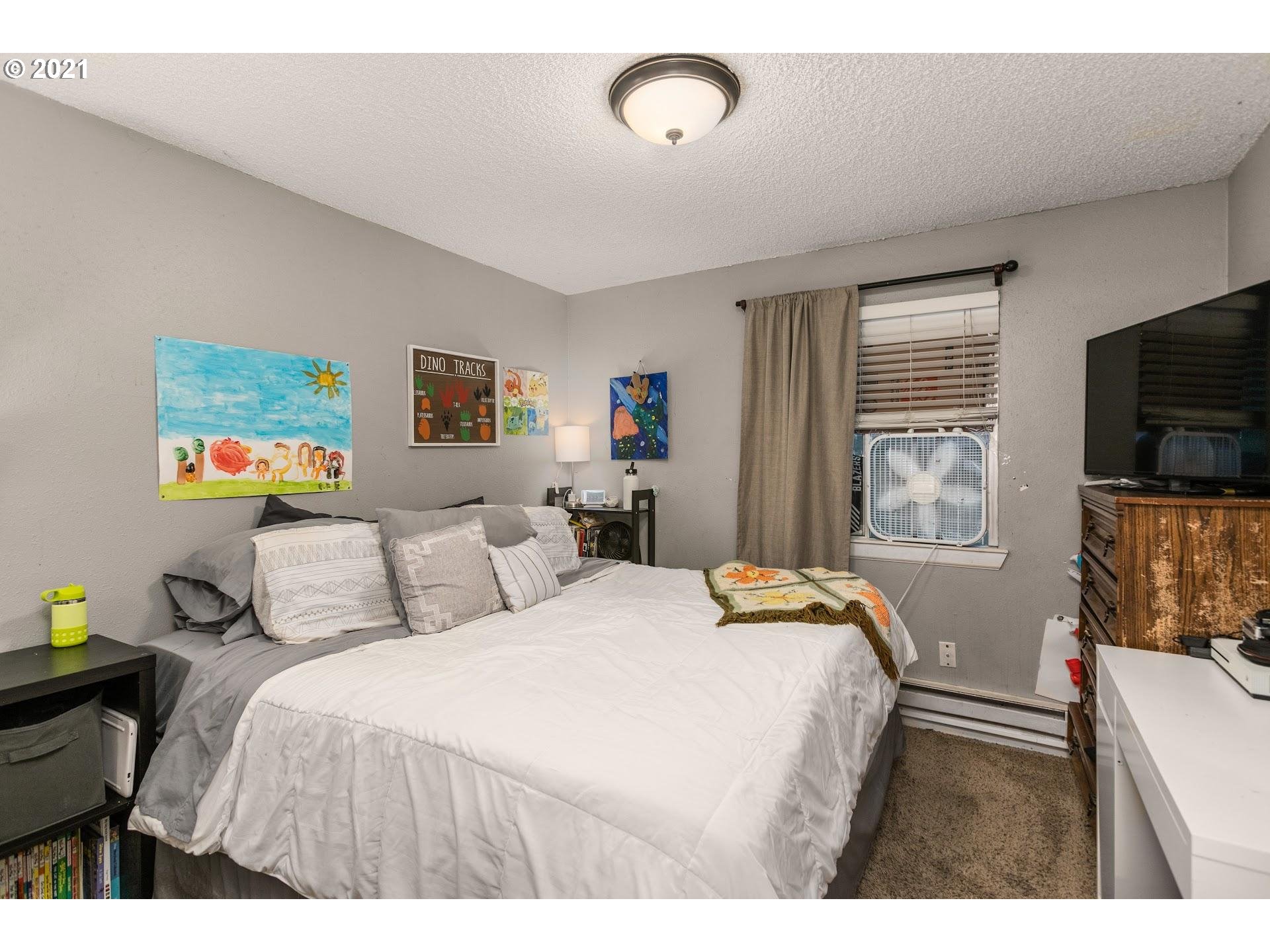 2943 Northeast Rene Avenue Gresham, OR 97030 - Photo 13 of 22 a bedroom with a bed and a flat screen tv