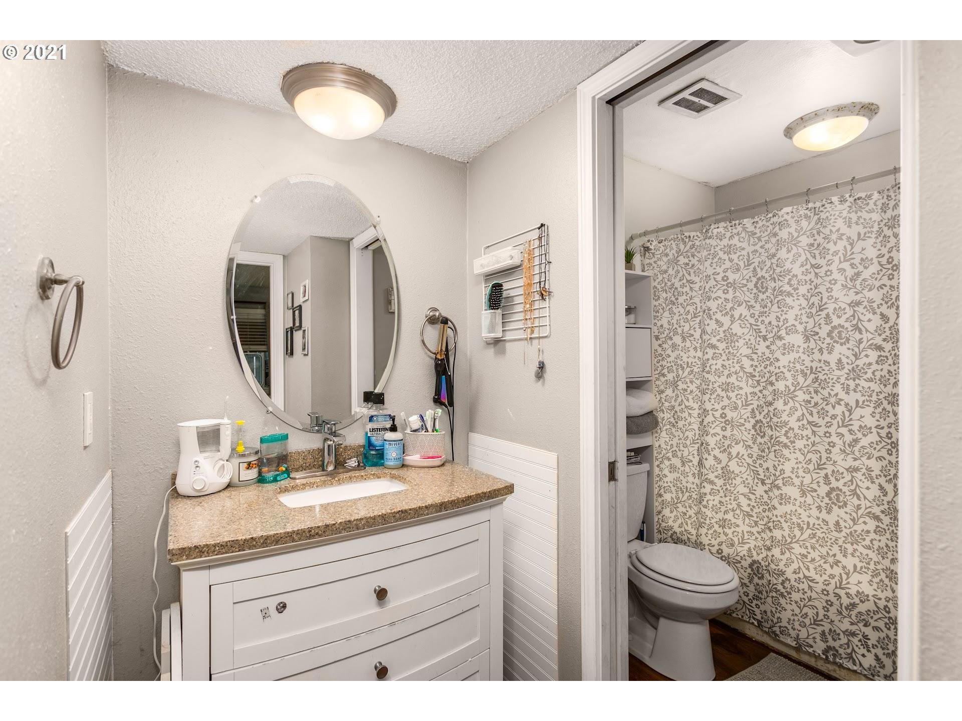 2943 Northeast Rene Avenue Gresham, OR 97030 - Photo 14 of 22 a bathroom with a granite countertop sink mirror and toilet