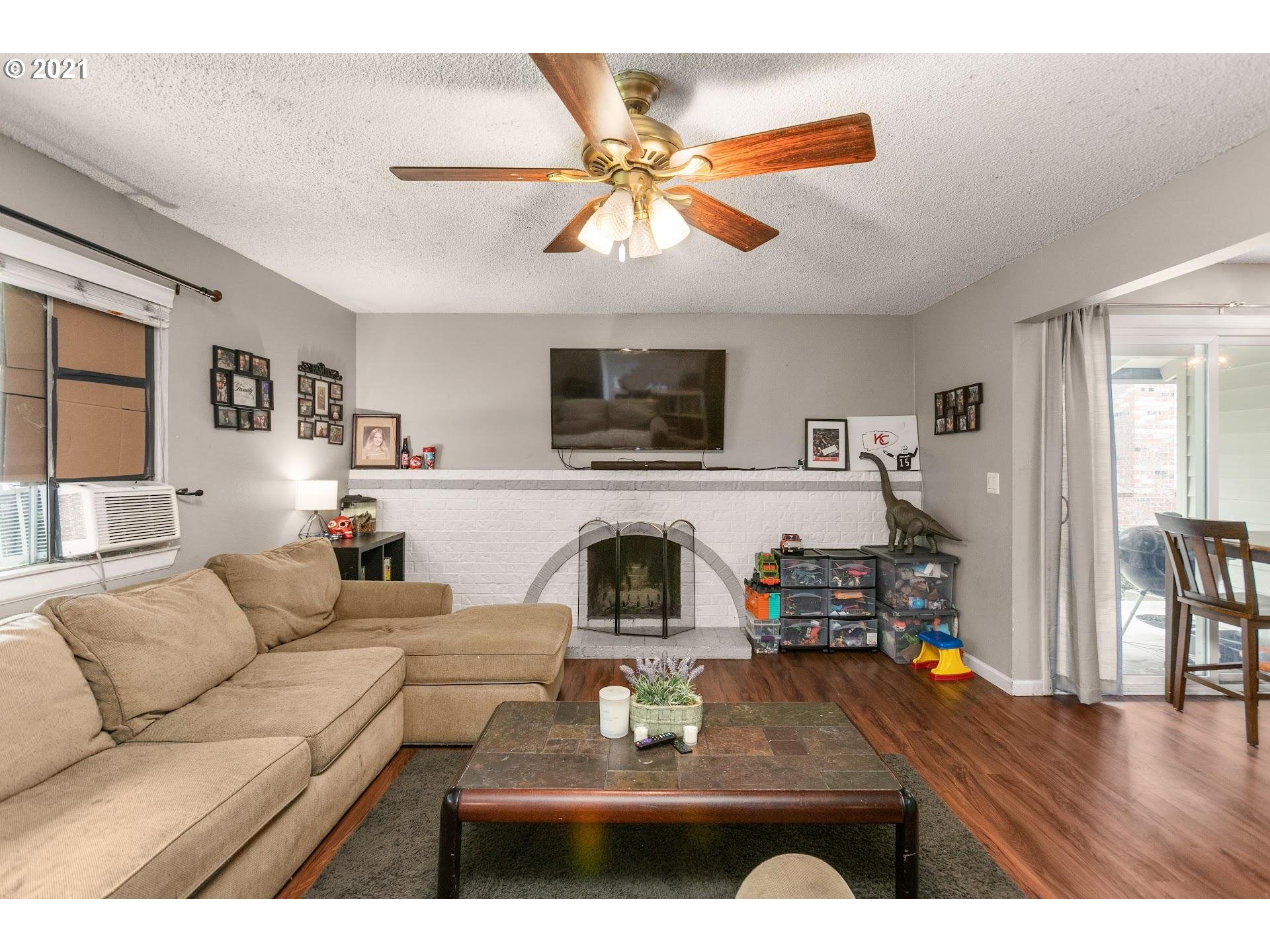 2943 Northeast Rene Avenue Gresham, OR 97030 - Photo 5 of 22 a living room with furniture a fireplace and a flat screen tv