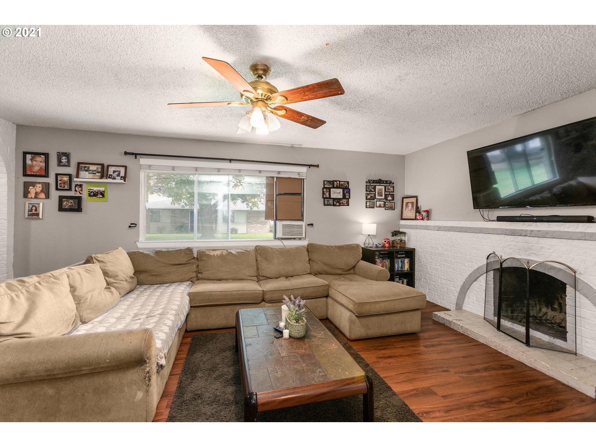 2943 Northeast Rene Avenue Gresham, OR 97030 - Photo 6 of 22 a living room with furniture a fireplace and a flat screen tv