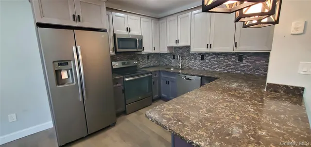 a kitchen with stainless steel appliances granite countertop a refrigerator sink and stove