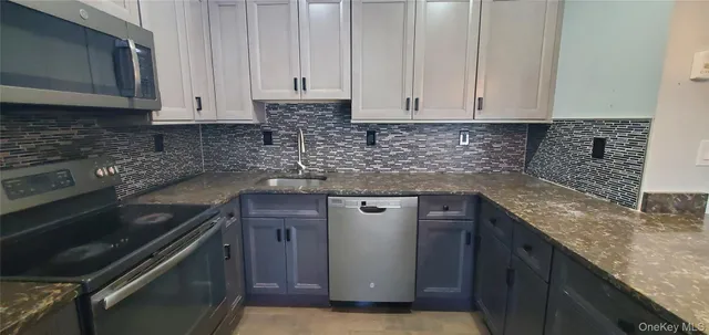 a kitchen with granite countertop a sink stove and cabinets
