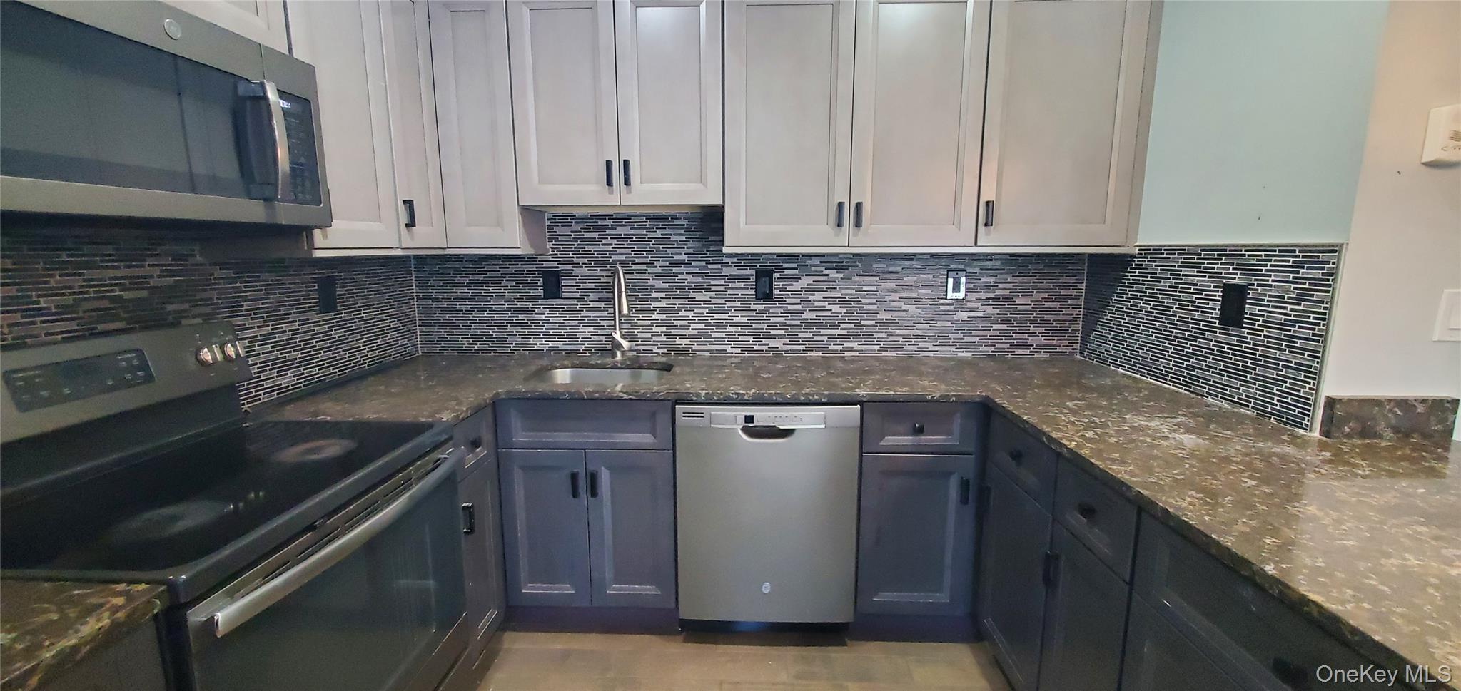 2755 West Main Street, Unit 1 Wappingers Falls, NY 12590 - Photo 6 of 15 a kitchen with granite countertop a sink stove and cabinets