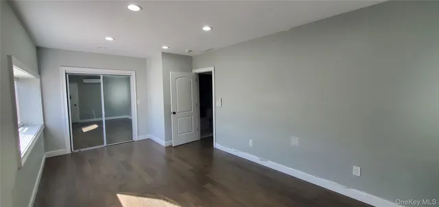 an empty room with wooden floor & windows