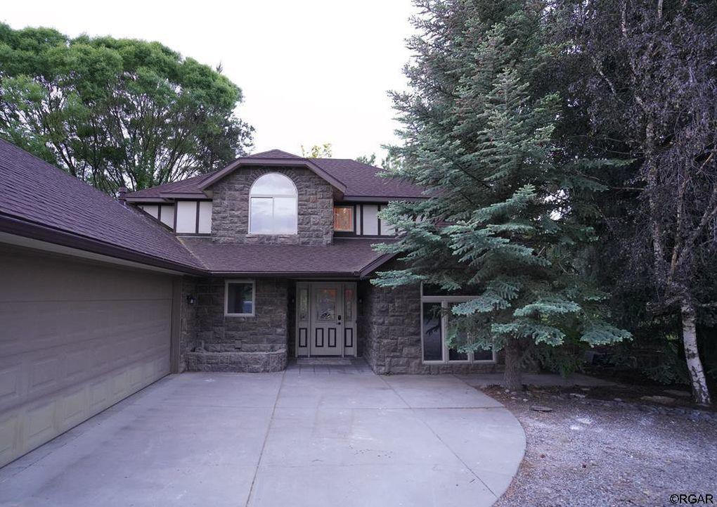 a front view of a house with a garden and tree