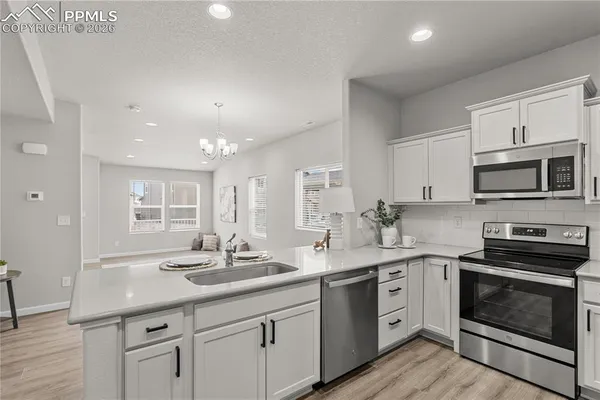 a kitchen with a sink stove and microwave