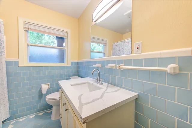 a bathroom with a sink a toilet and a mirror