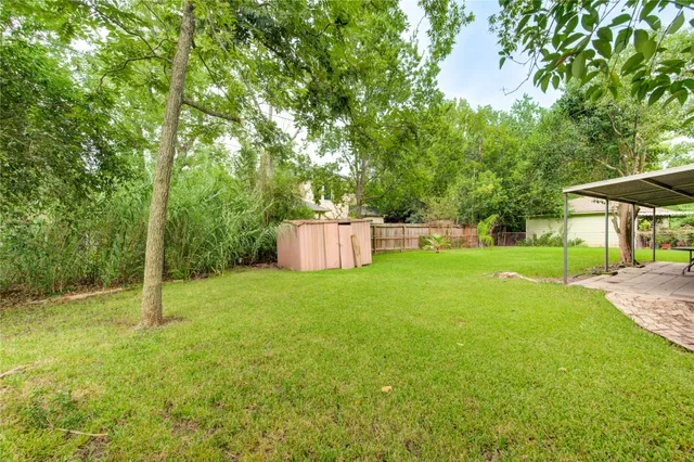 a view of a house with backyard and a tree