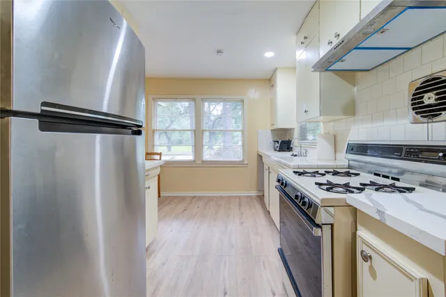 a kitchen with stainless steel appliances granite countertop a stove and a refrigerator