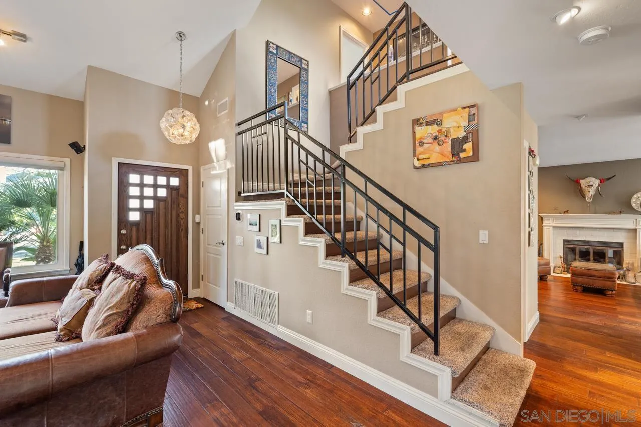 1815 Hawk View Drive Encinitas, CA 92024 - Photo 35 of 51 a living room with couches and a dining table with wooden floor