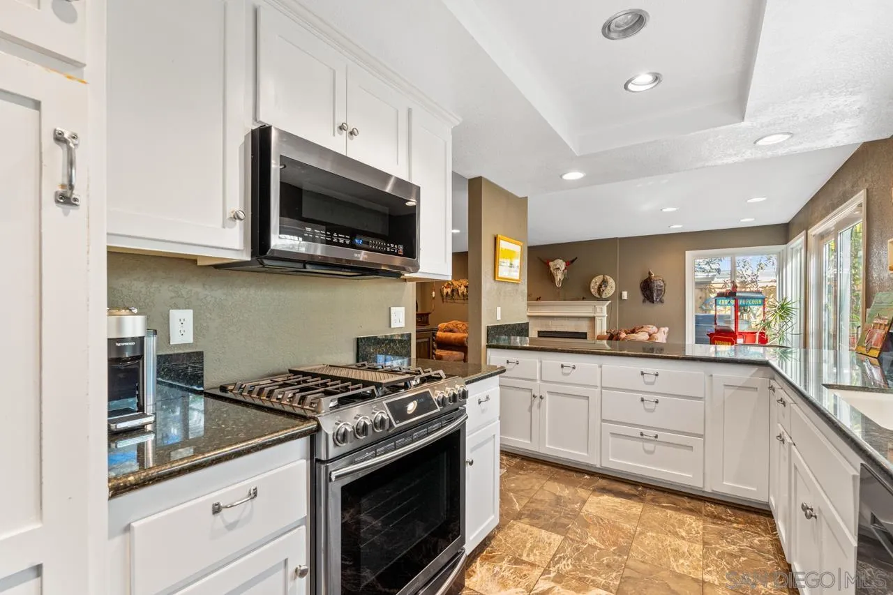 1815 Hawk View Drive Encinitas, CA 92024 - Photo 43 of 51 a kitchen with stainless steel appliances granite countertop grey cabinets a stove a sink and a microwave