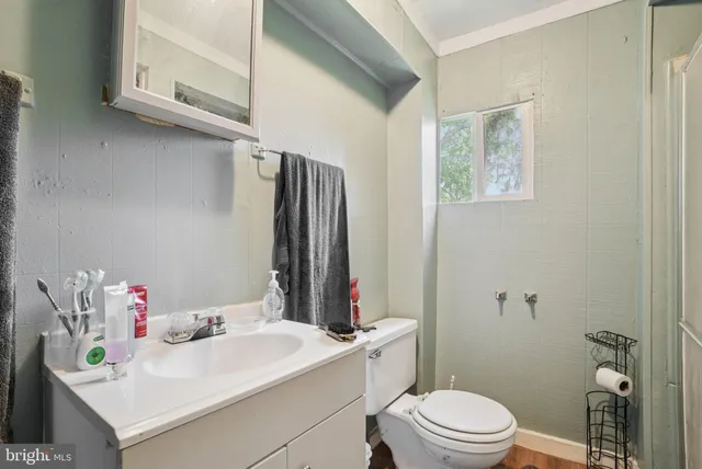 a bathroom with a sink vanity mirror and toilet