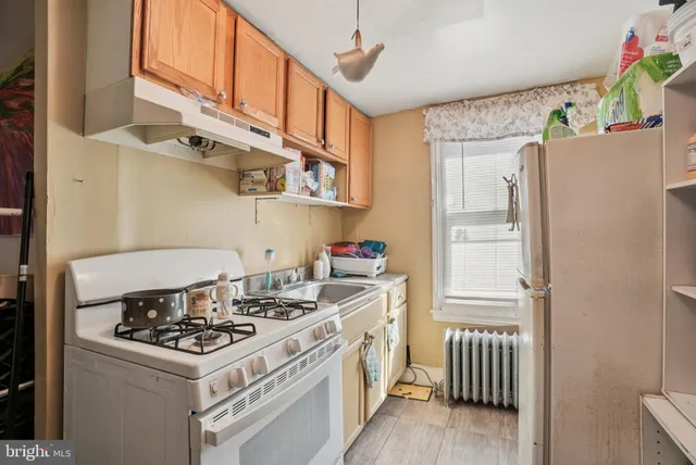 a kitchen with stainless steel appliances a stove a refrigerator and a cabinets