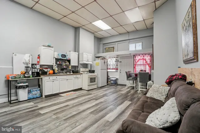 a living room with furniture and kitchen view