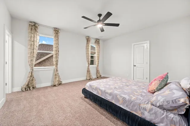 a bedroom with a bed and a ceiling fan