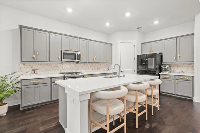 a kitchen with kitchen island granite countertop wooden cabinets and white stainless steel appliances