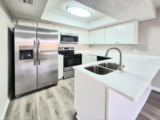 a kitchen with white cabinets and white appliances