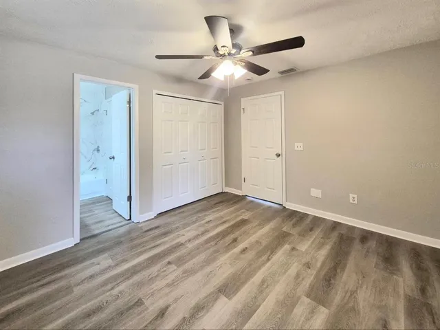 an empty room with a window and a fan