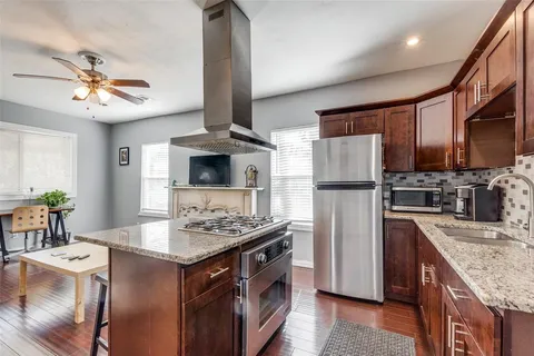 a kitchen with stainless steel appliances granite countertop a sink stove and refrigerator