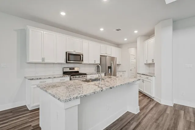 a kitchen with stainless steel appliances granite countertop a sink refrigerator and microwave