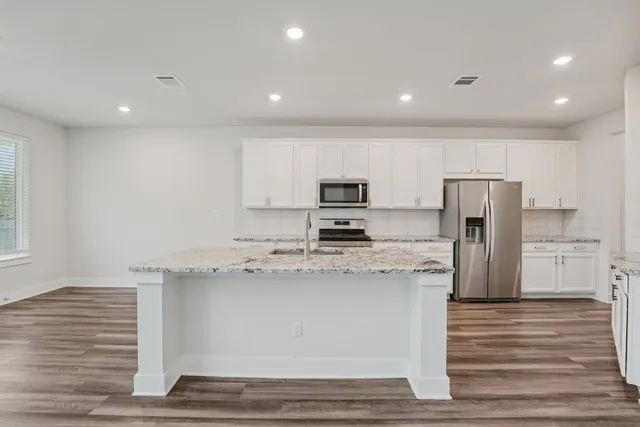 a kitchen with stainless steel appliances granite countertop a stove a sink and a refrigerator