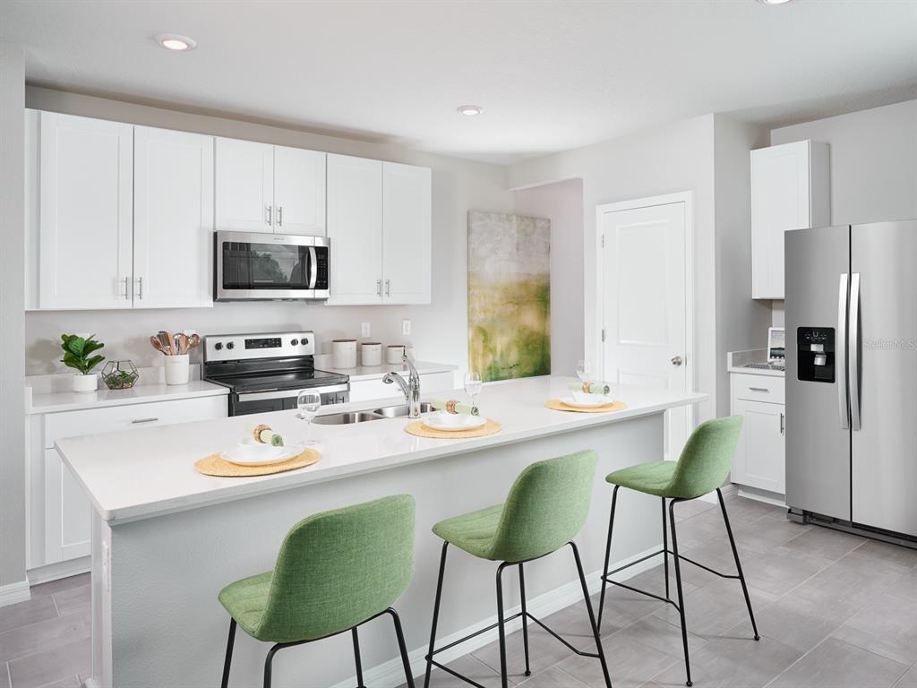 44505 Diamond Trail Punta Gorda, FL 33982 - Photo 2 of 7 a white kitchen with stainless steel appliances a white table and chairs in it