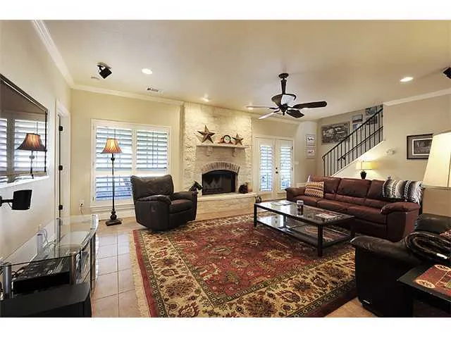 a living room with furniture a fireplace and a chandelier