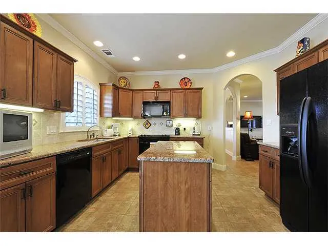 a kitchen with stainless steel appliances granite countertop a sink counter space and a window
