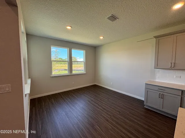 a kitchen with stainless steel appliances kitchen island wooden floors and large window