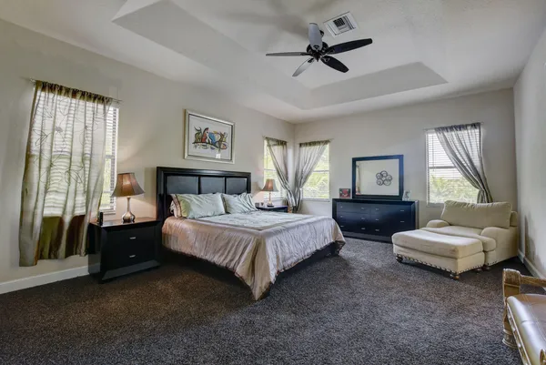 a spacious bedroom with a bed a couch and a window