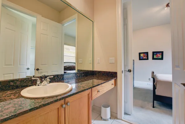 a bathroom with a granite countertop sink and a mirror