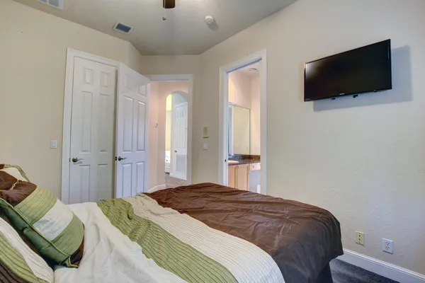 a bedroom with a bed and a flat screen tv