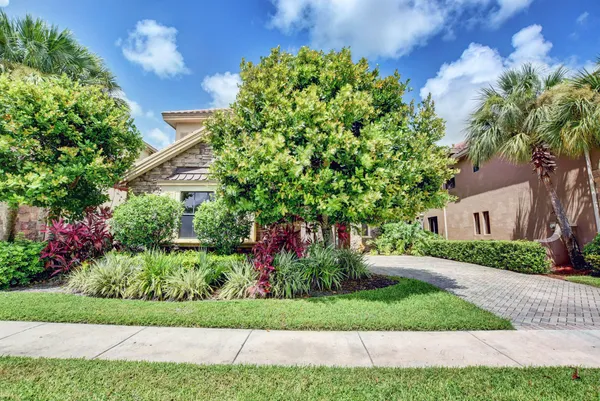 a front view of a house with a yard and potted plants