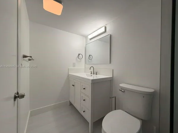 a spacious bathroom with a toilet sink and mirror