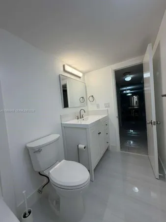 a spacious bathroom with a toilet a sink and mirror