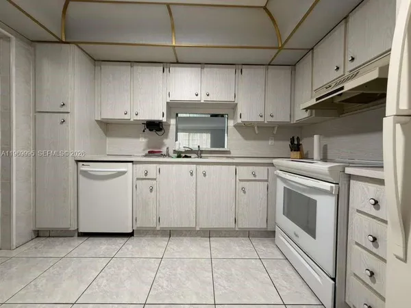 a kitchen with cabinets appliances and a sink