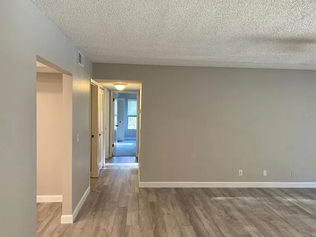 a view of a room with wooden floor and a bathroom