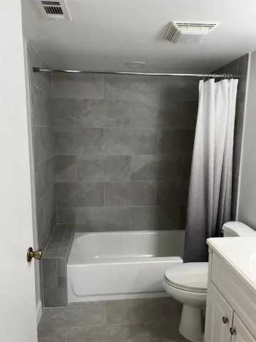 a bathroom with a shower a toilet and a bathtub