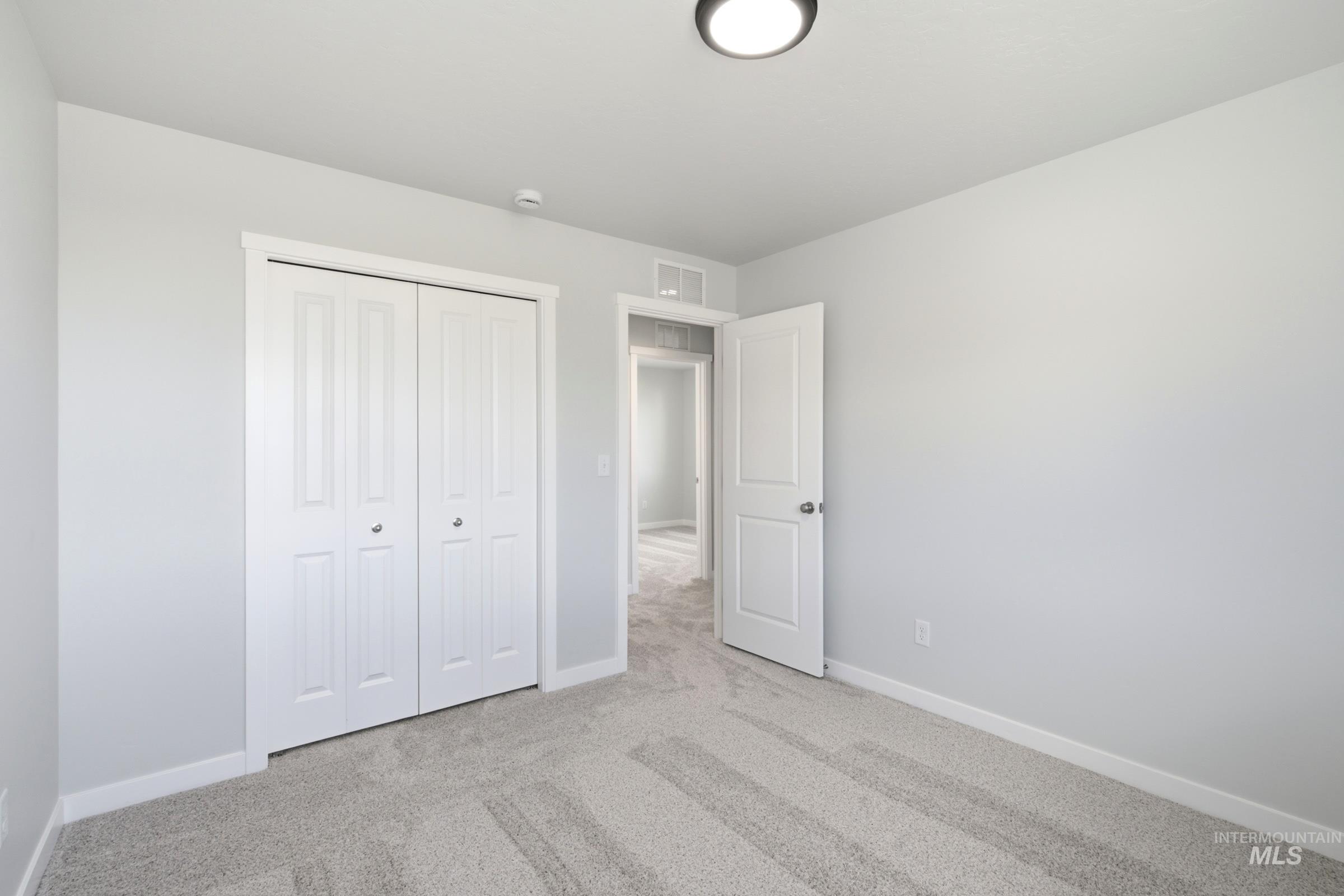 13324 Bank Street Caldwell, ID 83607 - Photo 18 of 29 Light-toned walls, white trim, and light gray carpet